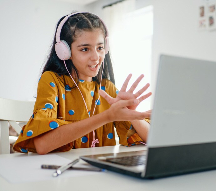 κορίτσι στο γραφείο χρησιμοποιεί φορητό υπολογιστή με ανοιχτό το Norton Family.