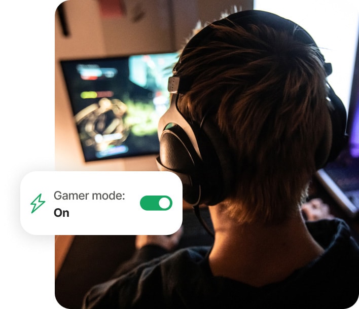 Αγόρι που παίζει παιχνίδια σε υπολογιστή χρησιμοποιώντας το Norton 360 for Gamers.